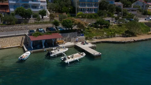 Die Uferanlage der Villa Sylvie mit Apartments im Hintergrund und Booten an ihren Liegeplätzen in Supetarska Draga.